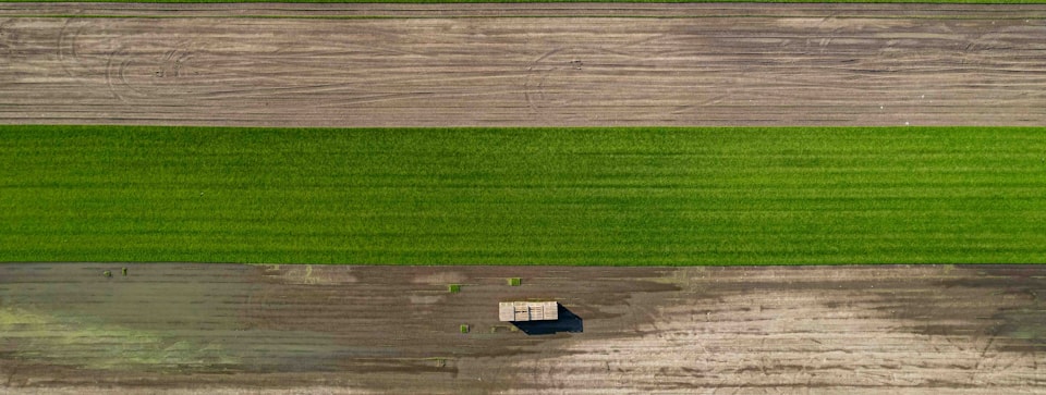 Aerial view of a tractor working a large crop field
