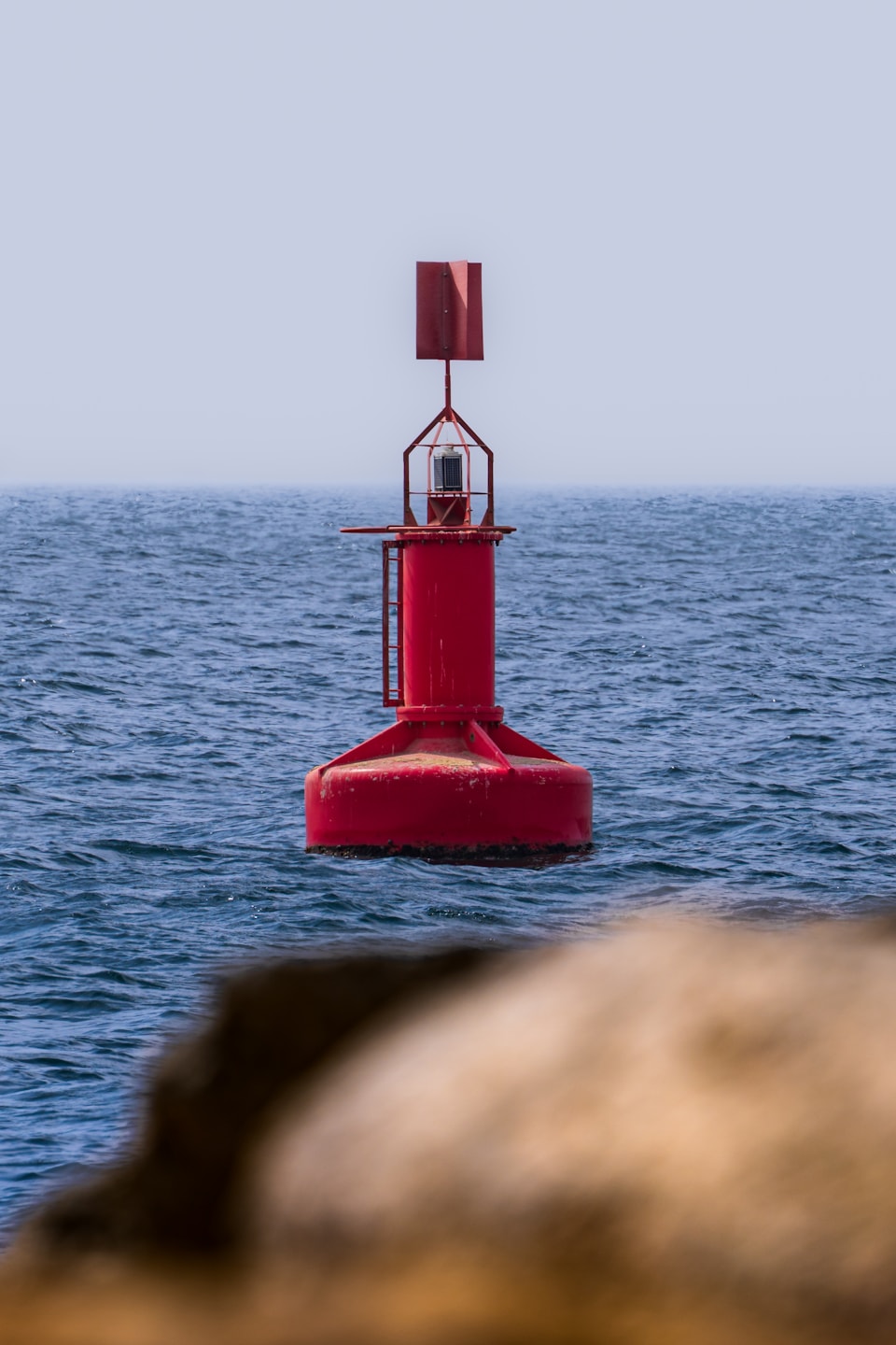 Red navigation buoy floating in open water