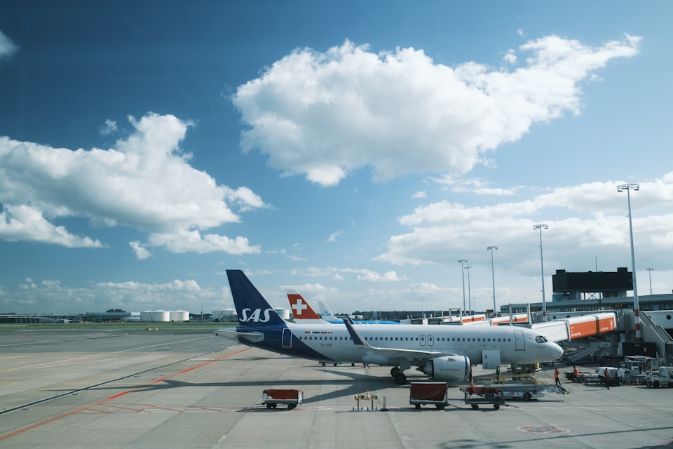Ground crew and cargo loaders working alongside an aircraft at an airport gate